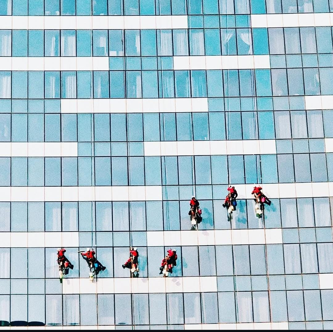 Équipe de techniciens cordistes sur une grande façade vitrée